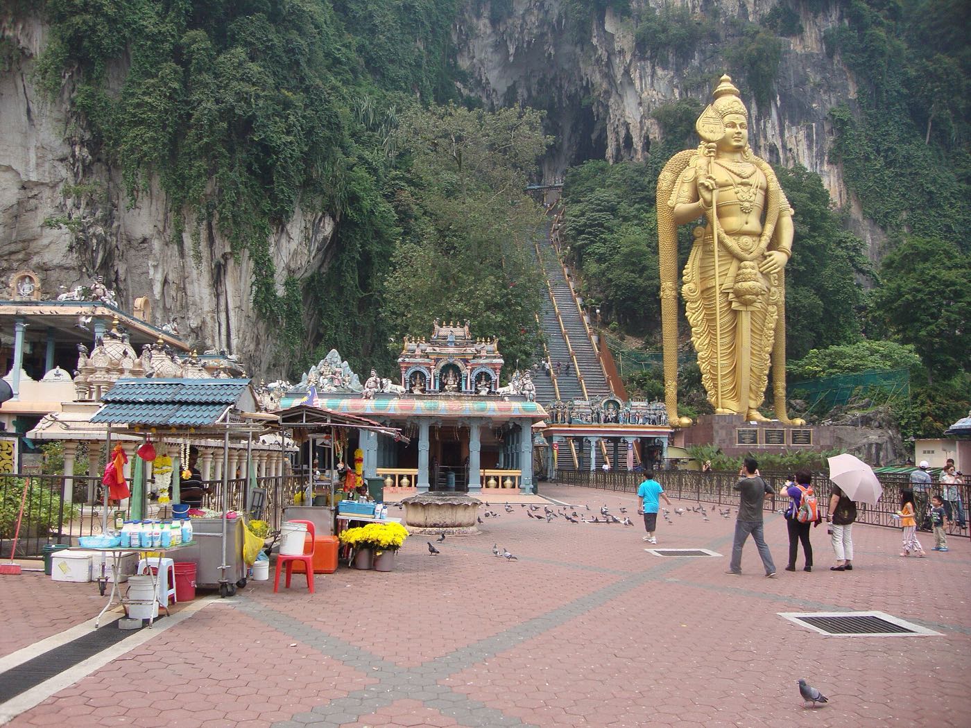 Golden statue of Lord Murugan beside the long staircase up to Batu Caves