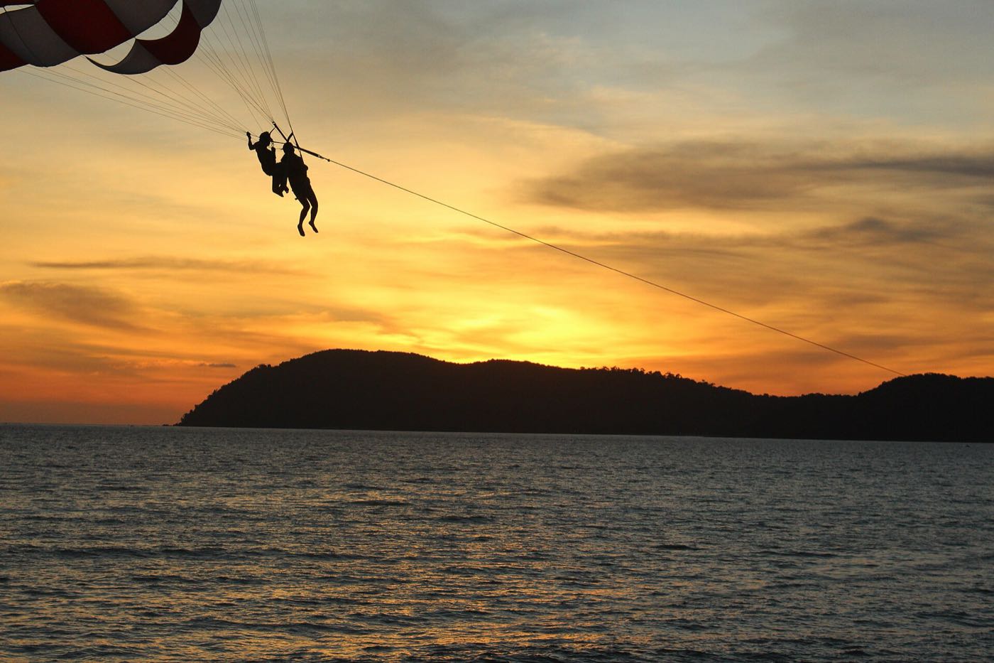 Parasailing over the sea at sunset in Langkawi